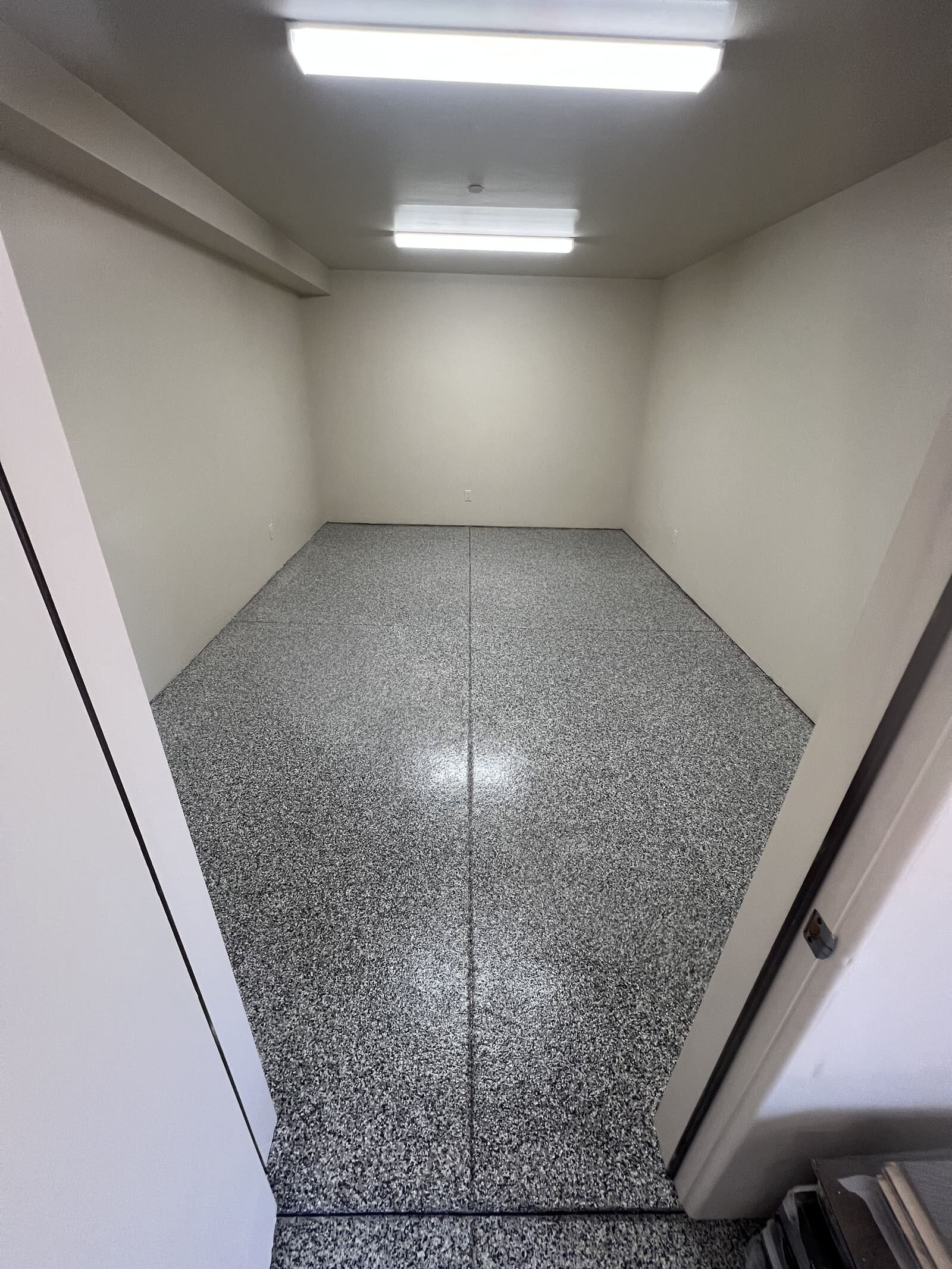 Gray epoxy flake garage floor coating with a seamless, high-gloss, UV-resistant finish designed for long-lasting residential durability.