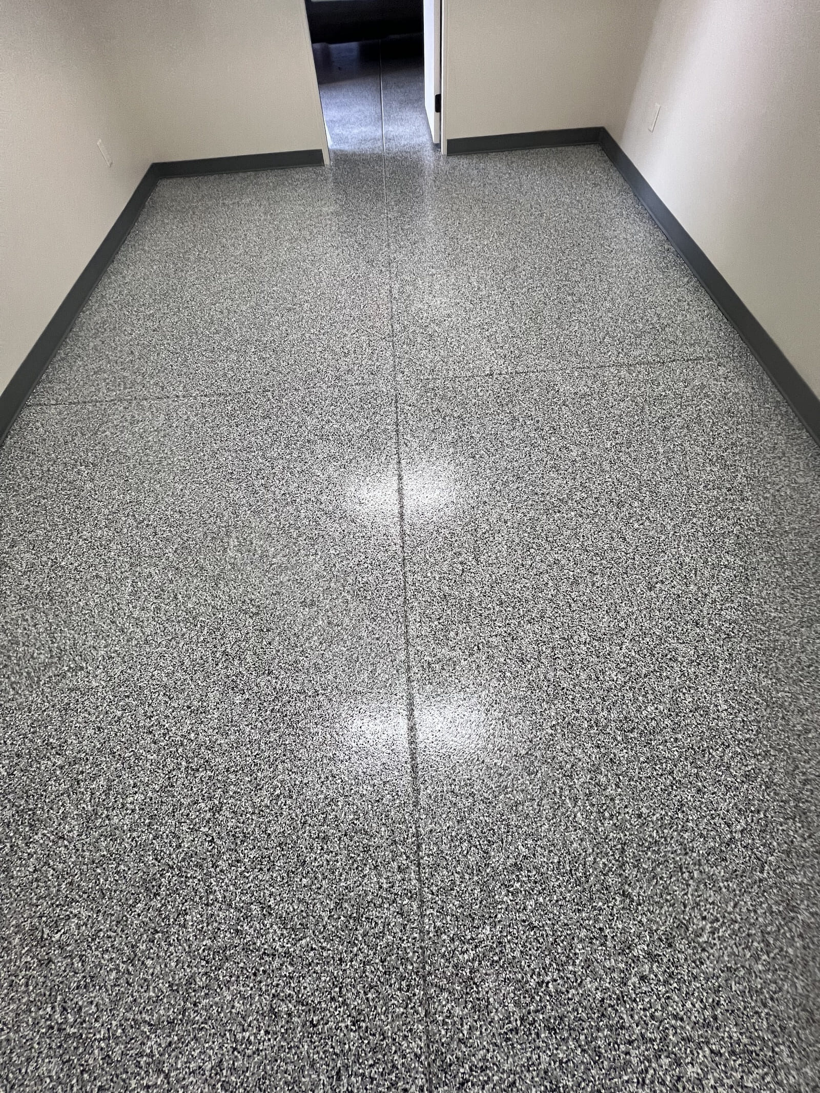 Glossy gray-and-black epoxy flake garage floor coating with a seamless, durable, UV-resistant finish installed by Northern Arizona Epoxy.